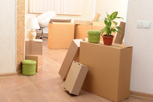 Professional movers carrying office equipment through a commercial building